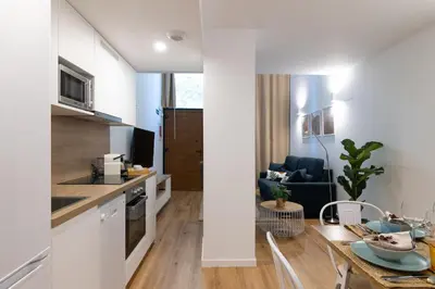 a kitchen and living room with a table in a room at DormForYou Alameda 12 Apartment in Valencia