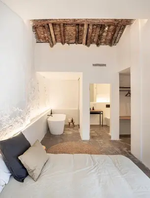 a white bedroom with a bed and a bath tub at Casa cristo 37 navarrés in Navarrés