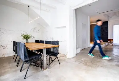 a man walking past a dining room with a table and chairs at Casa cristo 37 navarrés in Navarrés