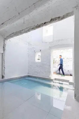 a person walking in a room with a swimming pool at Casa cristo 37 navarrés in Navarrés