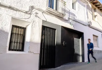 a man walking past a building with a black door at Casa cristo 37 navarrés in Navarrés