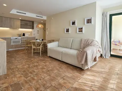 a living room with a couch and a kitchen at Apartamentos Las Ciencias Ñ in Valencia
