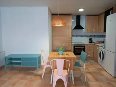 a kitchen with a table and chairs and a dining room at Apartamento Analema con piscina wifi y aire acondicionado in Moncófar