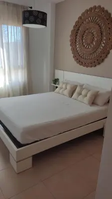 a bed in a bedroom with a white mattress at Playa de Canet, gran Terraza in Valencia