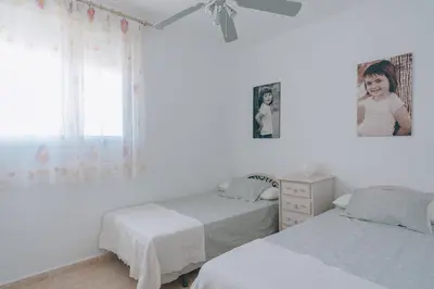a white bedroom with two beds and a window at Vivienda Turística Sunbeach-Xilxes VT-42192-CS in Xilxes
