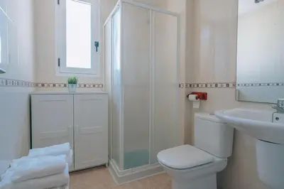 a white bathroom with a toilet and a sink at Vivienda Turística Sunbeach-Xilxes VT-42192-CS in Xilxes