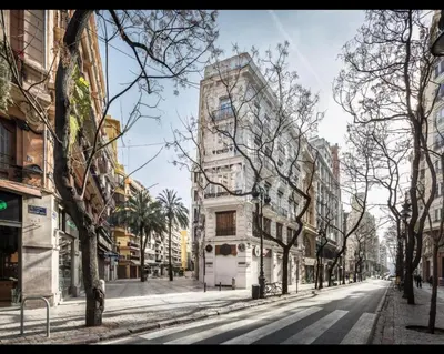 a tall white building on a city street at Valencia Aparthotel COSMO in Valencia
