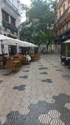 a cobblestone street with tables and chairs in a city at Valencia Aparthotel COSMO in Valencia