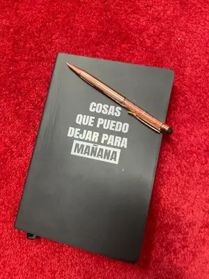 a notebook with a pencil on top of a red table at Valencia Aparthotel COSMO in Valencia