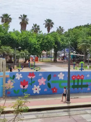 a woman walking past a wall in a park at Bright loft near the sea + BIKES in Valencia