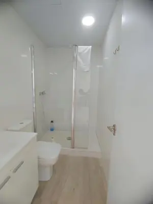 a white bathroom with a shower and a toilet at Bright loft near the sea + BIKES in Valencia