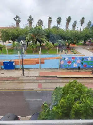 a park with palm trees and a blue fence at Close to the sea, large (170 m2) apartment+BIKES in Valencia