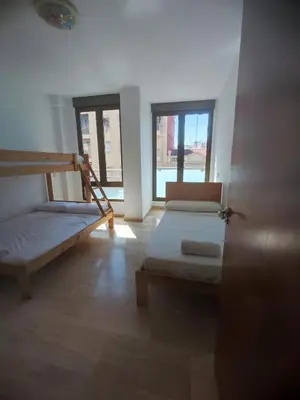 a room with two bunk beds and two windows at Close to the sea, large (170 m2) apartment+BIKES in Valencia
