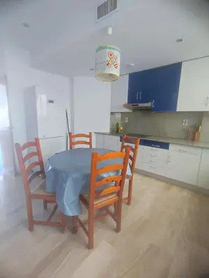 a kitchen with a blue table and chairs in a room at Close to the sea, large (170 m2) apartment+BIKES in Valencia