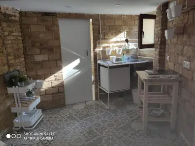 a kitchen with a door and a sink and a table at Cozy apartamento en Ruzafa para 2-3 personas con aire acondicionado y salida directa a terraza in Valencia
