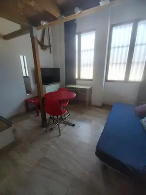 a bedroom with a bed and a table and a desk at Loft duplex industrial near the sea + bicicles in Valencia