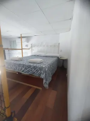 a bedroom with a bed with a blue blanket at Loft duplex industrial near the sea + bicicles in Valencia