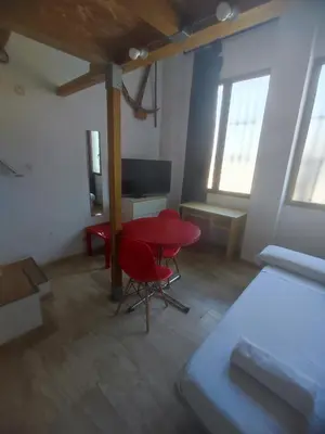 a room with a red table and a bed and a desk at Loft duplex industrial near the sea + bicicles in Valencia