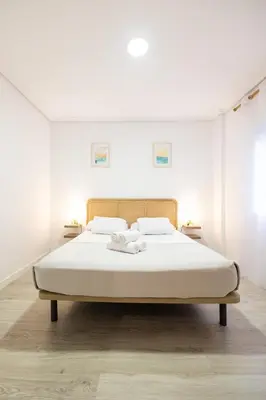 a bed in a white room with two towels on it at La casita de pescadores by Concept Flats in Valencia