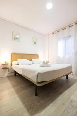 a white bedroom with a large bed in it at La casita de pescadores by Concept Flats in Valencia