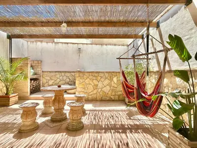 a patio with a hammock and a stone wall at Casa con jacuzzi y piscina con vistas al castillo in Corbera de Alcira