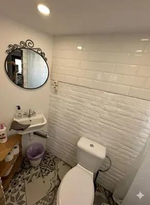 a bathroom with a toilet and a sink and a mirror at Precioso apartamento con a/a en Ruzafa con terracita privada y acceso a un jardín, para 2-3 personas in Valencia
