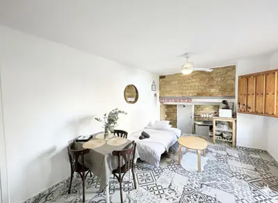a room with a bed and a table and chairs at Precioso apartamento con a/a en Ruzafa con terracita privada y acceso a un jardín, para 2-3 personas in Valencia