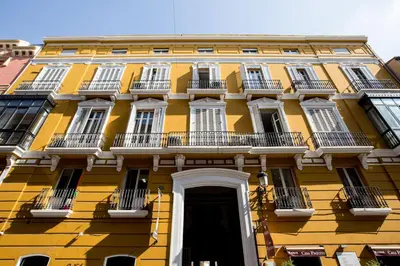 a yellow building with white windows and a door at Palacio de Rojas by Moontels in Valencia