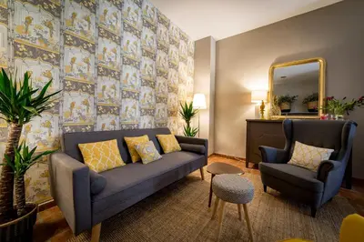 a living room with a blue couch and a mirror at Palacio de Rojas by Moontels in Valencia