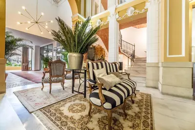 a lobby with two chairs and a table and a plant at Palacio de Rojas by Moontels in Valencia