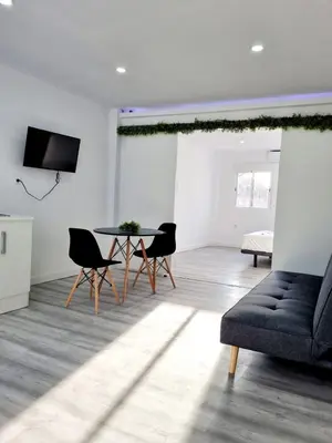 a living room with a table and chairs and a couch at Apartamentos T5 Valencia in Torrent
