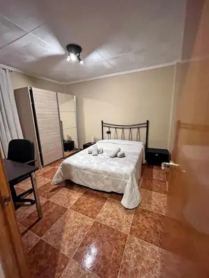 a bedroom with a bed and a tiled floor at Bonito y grande apartamento cerca de la playa in Valencia