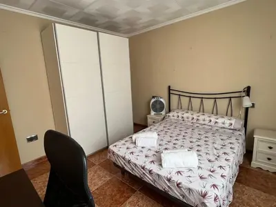 a bedroom with a bed and a chair at Bonito y grande apartamento cerca de la playa in Valencia