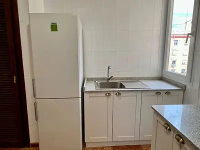 a kitchen with a white refrigerator and a sink at Bonito y grande apartamento cerca de la playa in Valencia