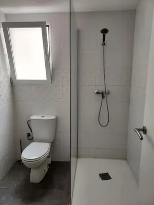 a bathroom with a toilet and a shower with a window at dama iberica II in Valencia