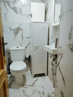 a white bathroom with a toilet and a sink at Florazar I frente a la playa in Cullera