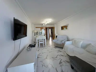 a living room with a couch and a flat screen tv at Florazar I frente a la playa in Cullera
