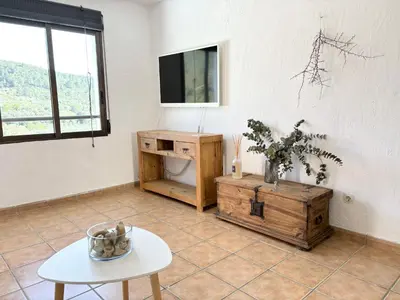 a living room with a table and a tv at Remote Work in Spanish Mediterranean Countryside in Vall de Almonacid