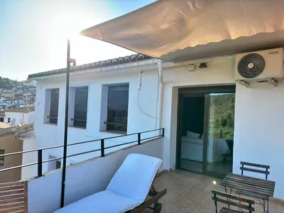a balcony with a couch and an umbrella at Remote Work in Spanish Mediterranean Countryside in Vall de Almonacid