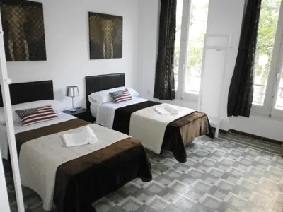 a room with two beds in a room with windows at Total Valencia Terrace in Valencia