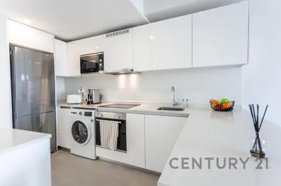 a kitchen with white cabinets and a washer and dryer at Luxury Apartment with 2 Bedrooms in Canet d'en Berenguer, Valencia in Canet de Berenguer
