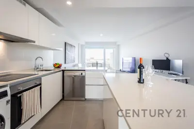 a white kitchen with a counter with a bottle of wine at Luxury Apartment with 2 Bedrooms in Canet d'en Berenguer, Valencia in Canet de Berenguer