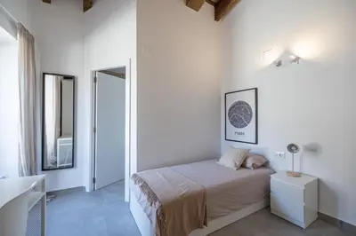 a white bedroom with a bed and a mirror at Residencia Universitaria Trinitarios in Valencia