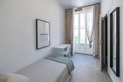 a bedroom with a bed and a desk and a window at Residencia Universitaria Trinitarios in Valencia