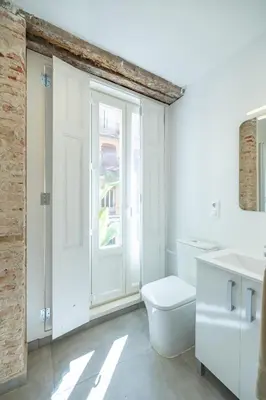 a white bathroom with a toilet and a window at Residencia Universitaria Trinitarios in Valencia
