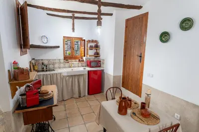 a kitchen with a table and a red refrigerator at Casa Rural La Corretger in Chulilla
