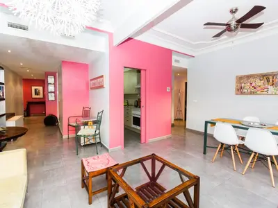 a living room with pink walls and a table and chairs at Total Valencia El Carmen (Leisure & Culture) in Valencia