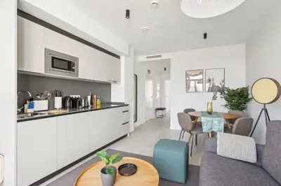 a kitchen and living room with a table and chairs at Limehome Valencia Calle de Cadiz in Valencia