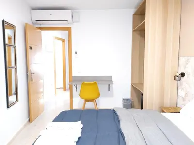 a bedroom with a blue bed and a yellow chair at Habitaciones Barra89 in Valencia