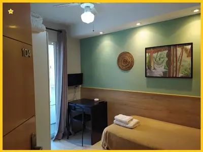 a hotel room with a bed and a desk at Habitaciones Barra89 in Valencia